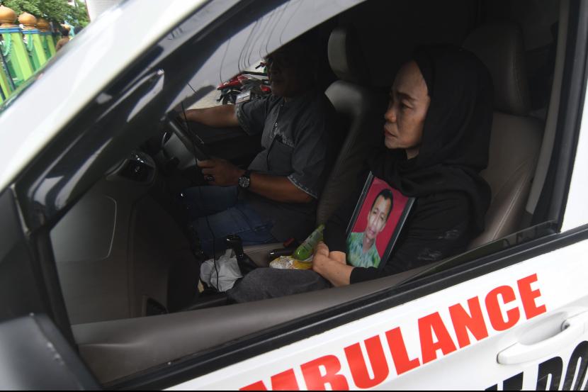 Nur Aisyah istri salah seorang korban penembakan kelompok kriminal bersenjata (KKB) membawa foto suaminya Mahmud Ismaun menuju lokasi pemakaman di Palu, Sulawesi Tengah, Senin (18/7/2022). Mahmud Ismaun yang merupakan supir pribadi Bupati Nduga menjadi salah satu korban penembakan KKB di Papua. 