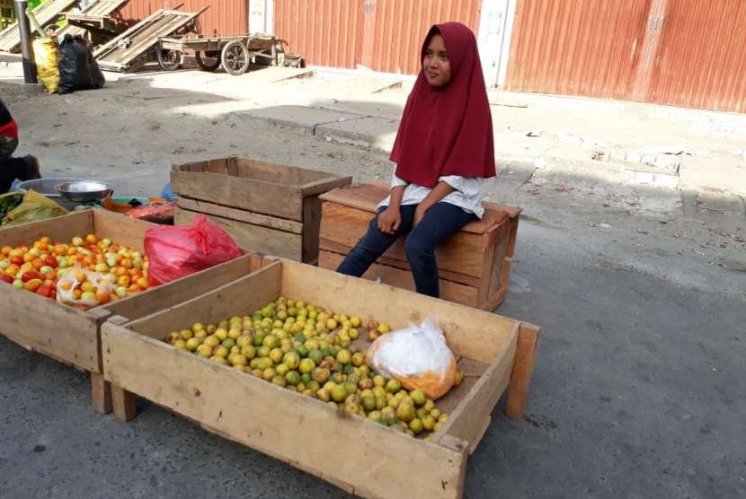 Nur Fainah (13 tahun) yang duduk di bangku sekolah kelas 2 SMP Negeri 5 Kabupaten Sigi sedang membantu ibunya berjualan di Pasar Inpres Manonda di Jalan Kacang Panjang, Kota Palu, Sulawesi Tengah. Fainah salah satu anak korban gempa bumi, impiannya menjadi seorang perancang busana.