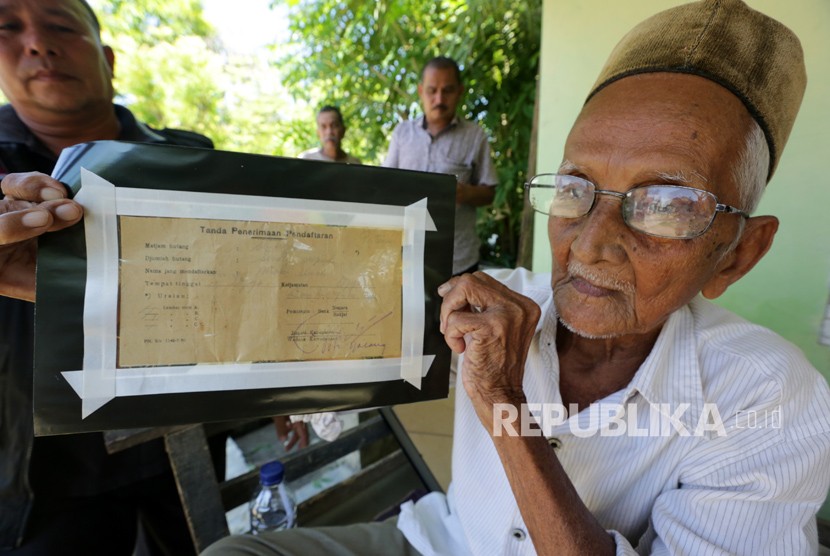 Nyak Sandang (kanan) memperlihatkan bukti obligasi pengumpulan uang untuk membeli pesawat pertama Indonesia di Desa Lhuet, Jaya, Aceh Jaya, Aceh, Rabu (14/3).