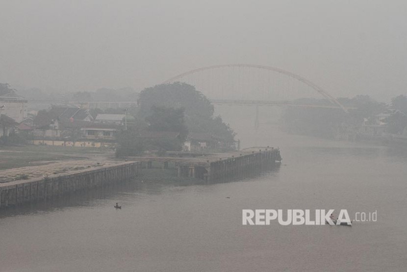 Ojek perahu menembus kabut asap pekat dampak dari kebakaran hutan dan lahan yang menyelimuti Kota Pekanbaru, Riau 