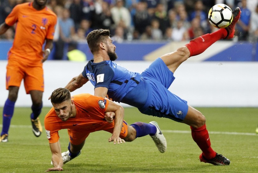 Olivier Giroud (kanan) dari Prancis ketika berduel dengan pemain Belanda Wesley Hoedt (kiri) pada kualifikasi Piala Dunia 2018 Grup A. Prancis mengalahkan Belanda 4-0 pada laga yang dihelat di Stadion Stade de France, Paris.