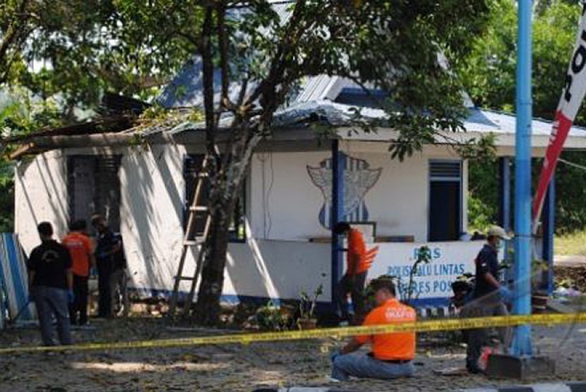 OM POSO. Sejumlah anggota kepolisian memeriksa tempat terjadinya ledkan bom di sebuah Pos Lalu Lintas di Kabupaten Poso, Sulawesi Tengah, Senin (22/10)
