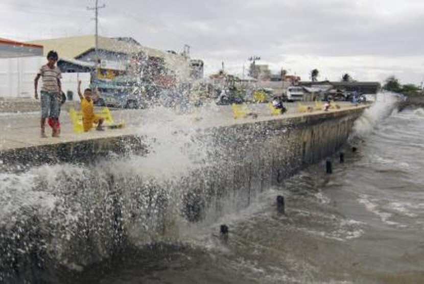Ombak akibat Badai Hagupit menerjang tembok beton di sepanjang The Boulevard Seaport di Surigao City, Filipina, Sabtu (6/12).
