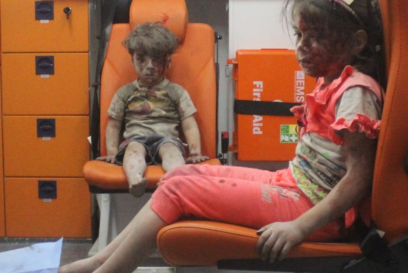  Omran Daqneesh yang berumur lima tahun duduk dengan wajah penuh darah, bersama kakaknya dalam ambulans setelah diselamatkan usai serangan udara di Aleppo, Suriah.