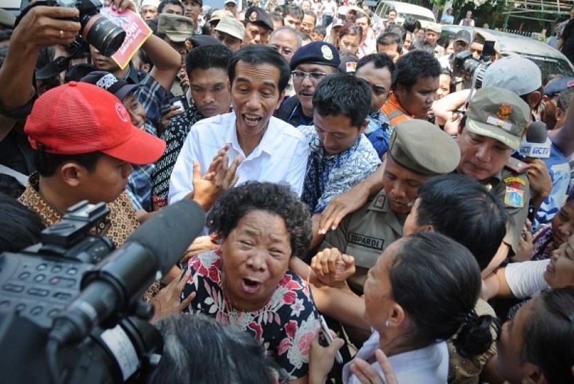 On the first day of his job as governor of Jakarta, Joko Widodo (in white) visits some slum areas in Jakarta, on Tuesday.  