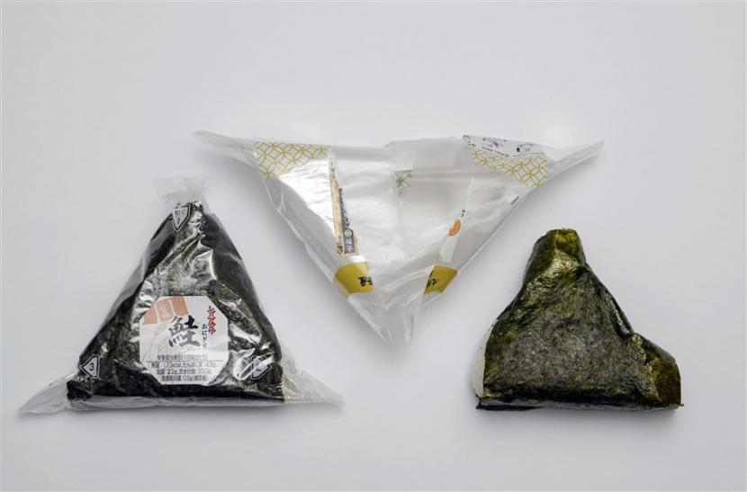 Onigiri. Satu lembar nori ukuran standar yang dibagi dua biasa digunakan untuk membungkus seluruh bagian onigiri.