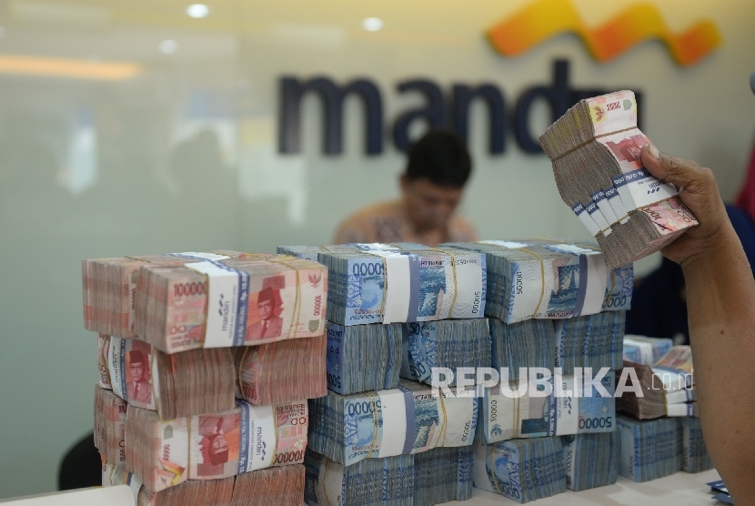 Nasabah menyetorkan uang tunai di salah satu cabang Bank mandiri, Jakarta, Jumat (6/5).  (Republika/Wihdan Hidayat)