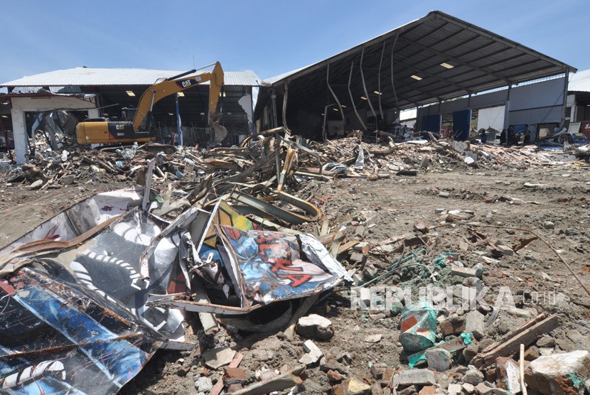 Operator alat berat membersihkan puing bangunan yang rusak pascagempa dan tsunami di Kawasan Pusat Pergudangan di Kelurahan Tondo, Palu, Sulawesi Tengah, Senin (22/10/2018). 