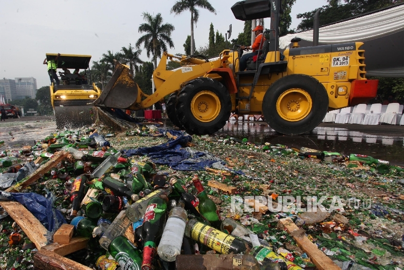 Operator alat berat memusnahkan ribuan minuman keras hasil operasi minuman beralkohol ilegal di kawasan Monas, Jakarta, Selasa (28/6).  (Republika/ Yasin Habibi)