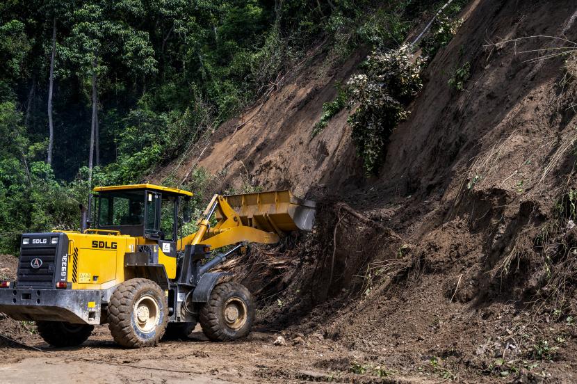 Operator alat berat menyingkirkan material longsoran yang menimbun jalan Trans Sulawesi (ilustrasi) 