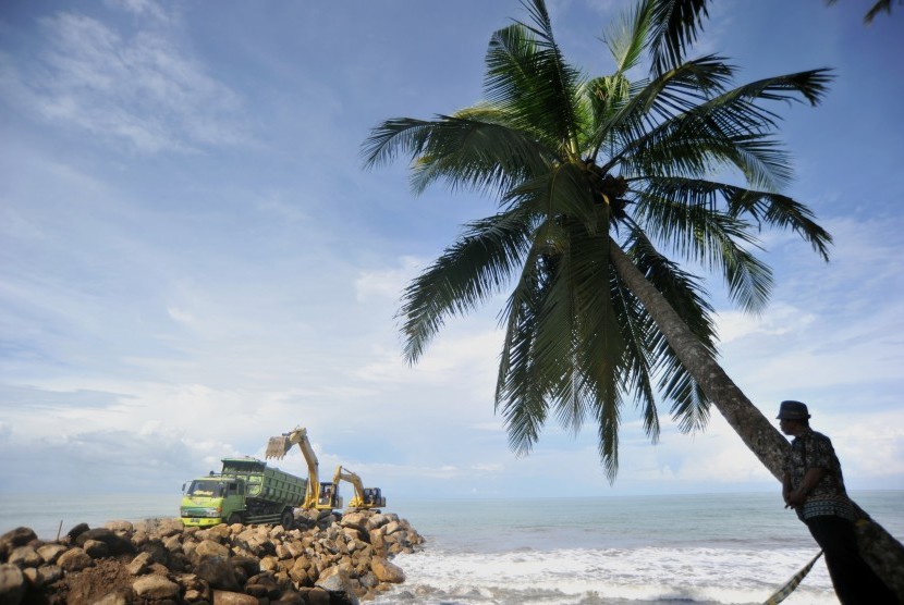 Operator alat berat menyusun batu grip di Pantai Ulakan, Padangpariaman, Sumatera Barat, Sabtu (20/4/2019).