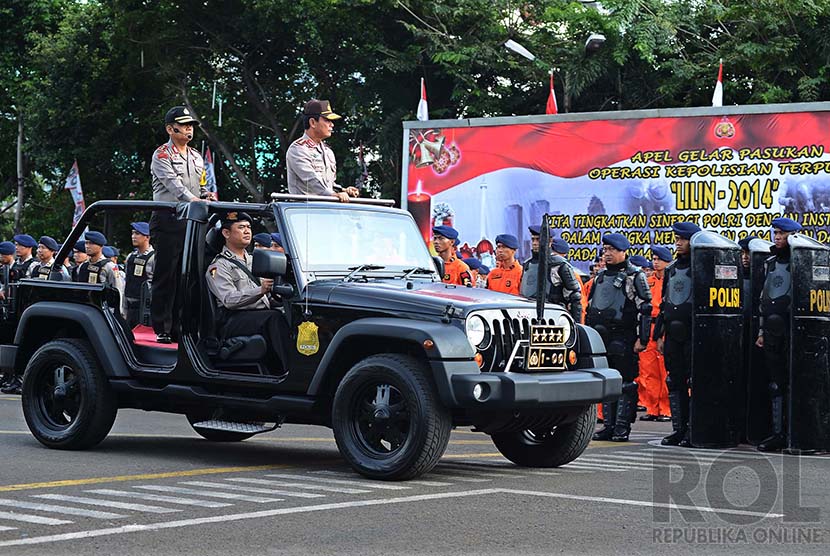 OPS Lilin 2014. Sejumlah anggota kepolisian bersiap untuk mengikuti apel gelar pasukan Operasi Pasukan Terpusat (OPS) Lilin di Lapangan Lalu Lintas, Polda Metro Jaya, Jakarta Selatan, Selasa (23/12).