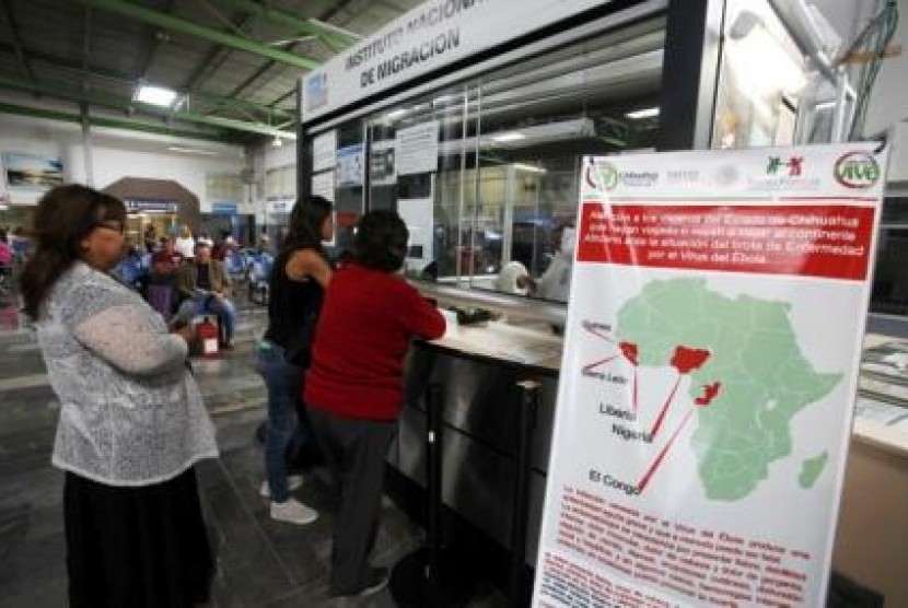 Orang mengantre di imigrasi yang berdampingan dengan papan yang memaparkan ebola di sebuah terminal bus di Meksiko (Dok). Lebih dari 1.040 petugas imigrasi Meksiko harus mengundurkan diri atau menjalani pemeriksaan internal akibat praktik korupsi. 