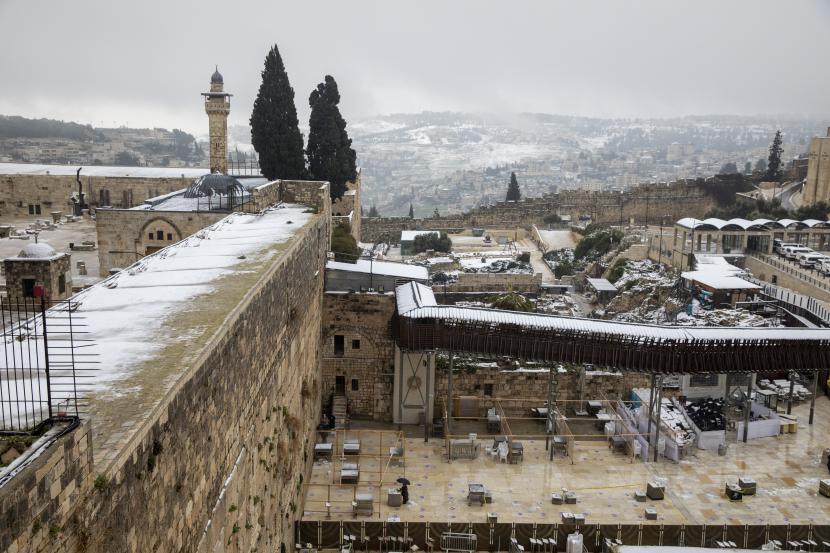 Orang-orang berdoa di Tembok Barat, situs paling suci tempat orang Yahudi dapat berdoa, di kota tua Yerusalem, setelah badai salju, Kamis, 18 Februari 2021.