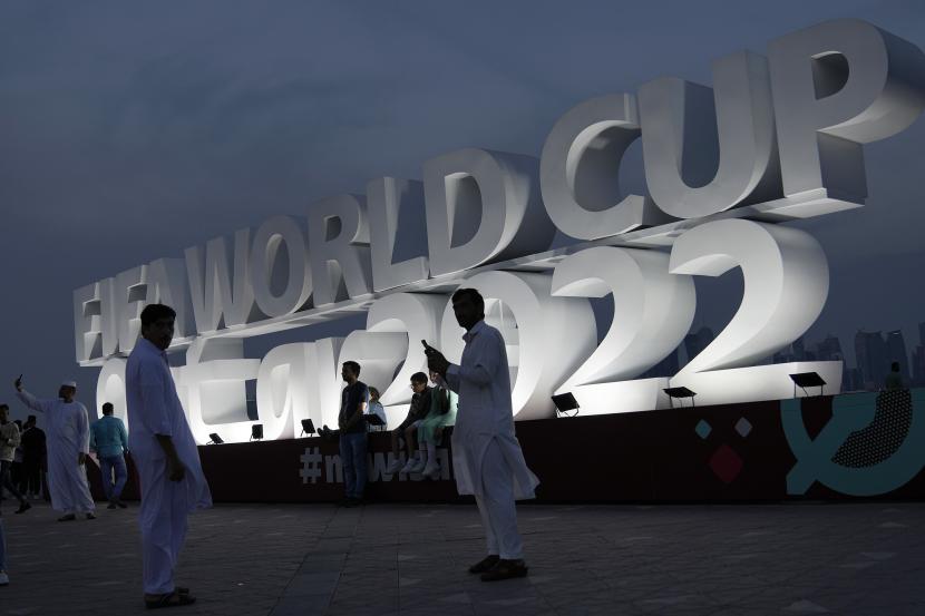  Orang-orang berfoto dengan tulisan dalam bahasa Inggris Piala Dunia Qatar 2022 di Qatar. FIFA Larang Penjualan Alkohol di Stadion Piala Dunia Qatar