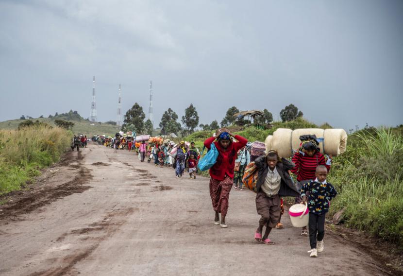 Orang-orang berjalan di jalan dekat Kibumba, utara Goma, Republik Demokratik Kongo, saat mereka melarikan diri dari pertempuran antara pasukan Kongo dan pemberontak M23 di Kivu Utara, Selasa 24 Mei 2022.