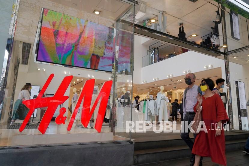 Orang-orang berjalan melewati toko pakaian H&M di Hong Kong, Sabtu (27/3). H&M menghilang dari internet di China ketika pemerintah meningkatkan tekanan pada merek sepatu dan pakaian dan mengumumkan sanksi pada hari Jumat (26/3), terhadap pejabat Inggris di a pertengkaran yang meningkat atas keluhan pelanggaran di wilayah Xinjiang.