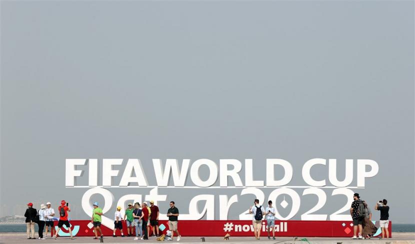  Orang-orang berkumpul di depan patung berlogo Piala Dunia FIFA 2022 di tepi pantai dekat pasar tradisional Souq Waqif di Doha, Qatar, 20 November 2022. Brand fashion lokal asal Jakarta, Roughneck 1991, mengumumkan kerja sama dengan FIFA untuk Piala Dunia 2022.