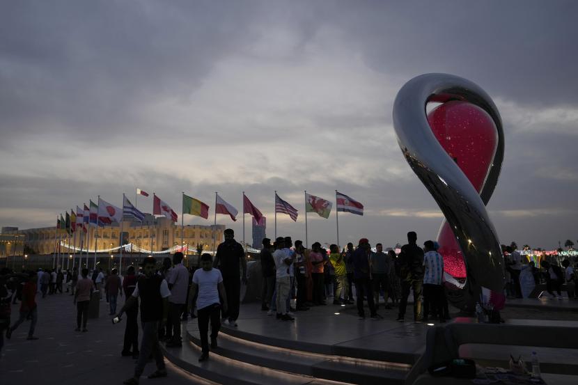 Orang-orang berkumpul di sekitar jam hitung mundur resmi yang menunjukkan sisa waktu hingga kick-off Piala Dunia 2022 di Doha, Qatar, Kamis, 17 November 2022. Persiapan terakhir sedang dilakukan untuk Piala Dunia sepak bola yang dimulai pada 20 November ketika Qatar menghadapi Ekuador. Qatar Kenalkan Islam Lewat Piala Dunia 2022