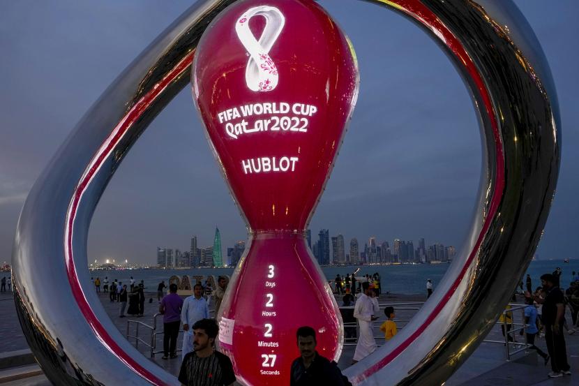  Orang-orang berkumpul di sekitar jam hitung mundur resmi yang menunjukkan sisa waktu hingga kick-off Piala Dunia 2022 di Doha, Qatar, Kamis, 17 November 2022. Persiapan terakhir sedang dilakukan untuk Piala Dunia sepak bola yang dimulai pada 20 November ketika Qatar menghadapi Ekuador. 
