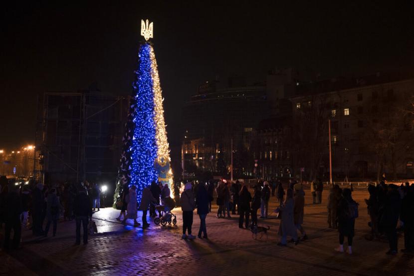 Orang-orang berkumpul di sekitar pohon Natal yang dihiasi warna bendera nasional Ukraina di alun-alun Sophia di Kyiv, Ukraina, Jumat, 23 Desember 2022.