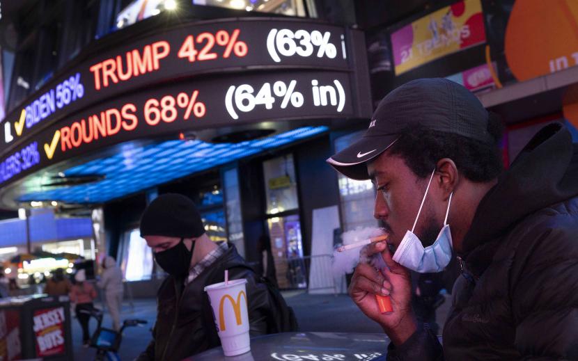 Orang-orang berkumpul untuk menonton hasil pemilihan presiden di layar di Times Square di New York, New York, AS, 03 November 2020. Amerika Serikat (AS) melaporkan lebih dari 128.000 kasus virus corona baru pada hari Jumat (6/11).