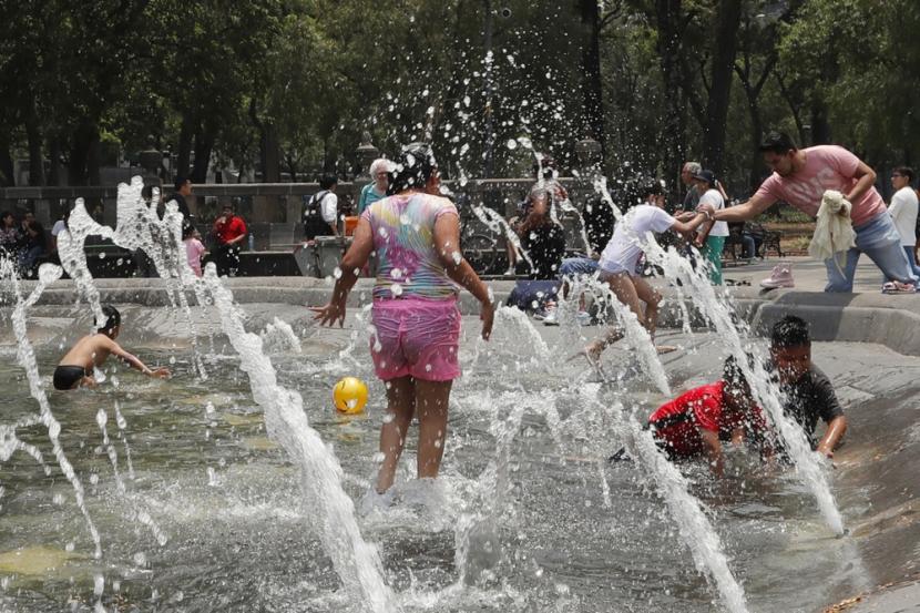 Orang-orang bermain di air mancur di Alameda Central di Mexico City, Meksiko, 12 Mei 2024. Gelombang panas tersebut menyebabkan 48 orang meninggal sejak Maret 2024.