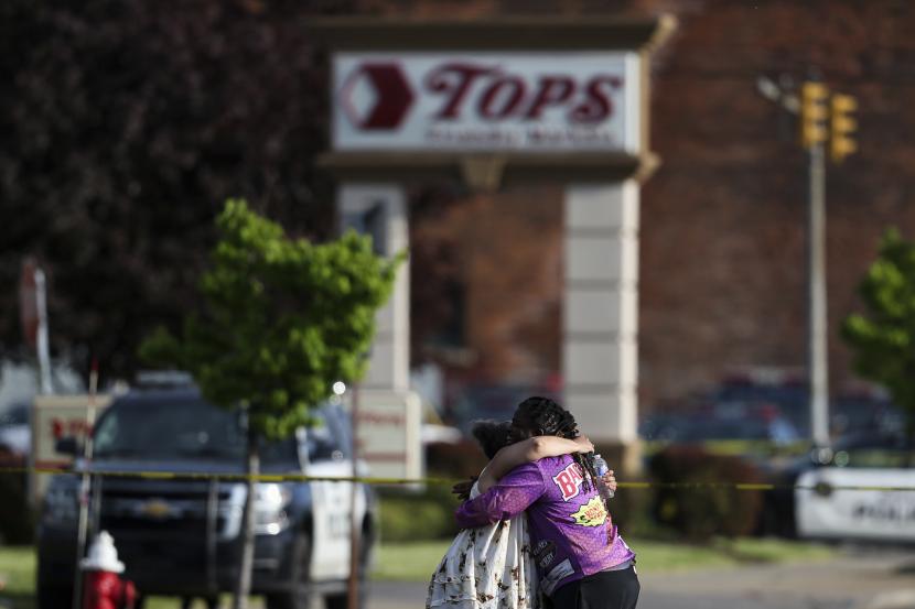 Orang-orang berpelukan di luar tempat kejadian setelah penembakan di supermarket pada Sabtu, 14 Mei 2022, di Buffalo, N.Y.