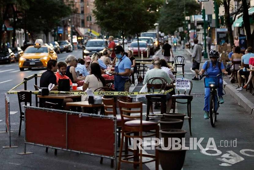 Orang-orang makan di luar di Columbus Avenue di New York, New York, AS, 22 Juni 2020. Kota New York secara resmi memulai Fase Dua dengan sebagian besar kegiatan dibuka kembali setelah ditutup selama 100 hari karena pandemi coronavirus. 
