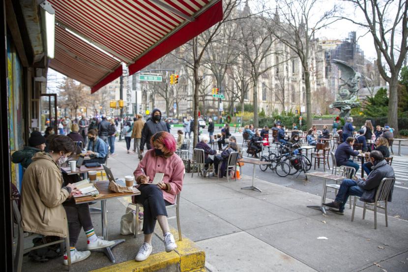 Orang-orang makan di meja restoran di blok jalan yang ditutup untuk lalu lintas kendaraan untuk memungkinkan jarak sosial dan makan di luar ruangan selama pandemi virus corona di wilayah Manhattan di New York City pada Ahad, 13 Desember 2020. Kepala Penasihat Medis untuk Presiden Amerika Serikat (AS) Dr Anthony Fauci mengatakan pada Rabu (27/4/2022), bahwa virus corona berada di bawah kendali yang lebih baik di AS.