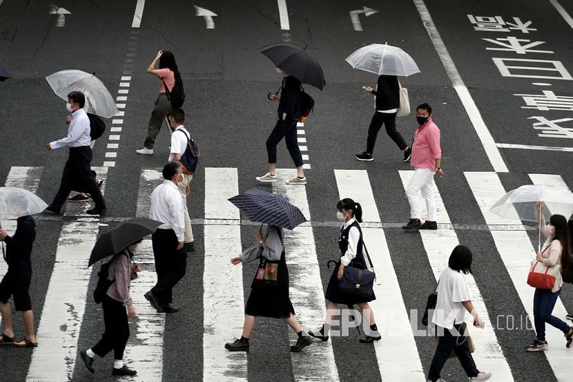  Orang-orang memakai masker berjalan di Tokyo. Pemerintah Tokyo kemungkinan akan menyatakan keadaan darurat jika kasus virus corona di ibu kota Jepang itu terus memburuk. Hal tersebut dinyatakan Gubernur Tokyo, Jumat (31/7).