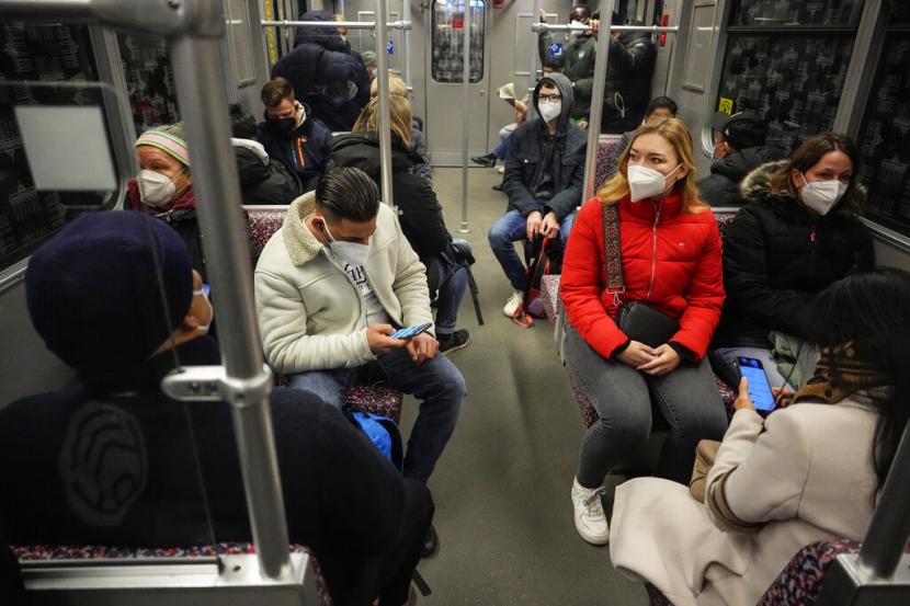 Orang-orang memakai masker wajah untuk melindungi diri dari virus corona, melakukan perjalanan dengan metro di Berlin, Jerman, 31 Maret 2022.