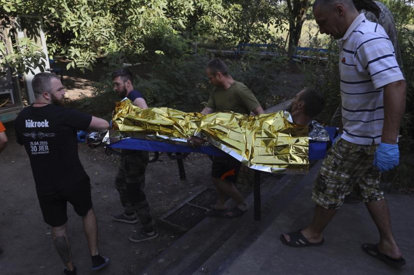 Orang-orang membawa prajurit Ukraina yang terluka di titik stabilisasi medis garis depan di wilayah Zaporizhzhia, Ukraina, Kamis, 27 Juli 2023.