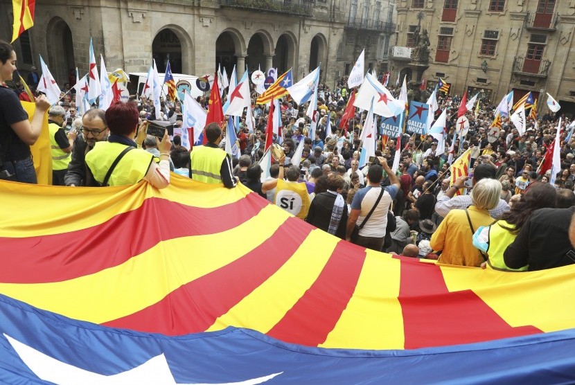 Orang-orang membentangkan bendera pro-kemerdekaan Katalunya dalam sebuah demonstrasi di Santiago de Compostela, Provinsi Galicia, Spanyol, Sabtu (30/9). Katalunya mengadakan referendum kemerdekaan pada Ahad (1/10), meski telah dilarang oleh Mahkamah Konstitusi Spanyol.