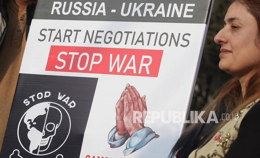 Orang-orang memegang plakat menuntut diakhirinya perang Rusia-Ukraina.