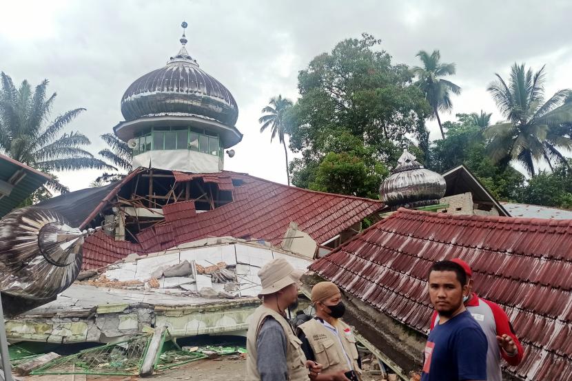Orang-orang memeriksa masjid yang rusak setelah gempa bumi di Pasaman, Sumatera Barat, Indonesia, Jumat, 25 Februari 2022. 