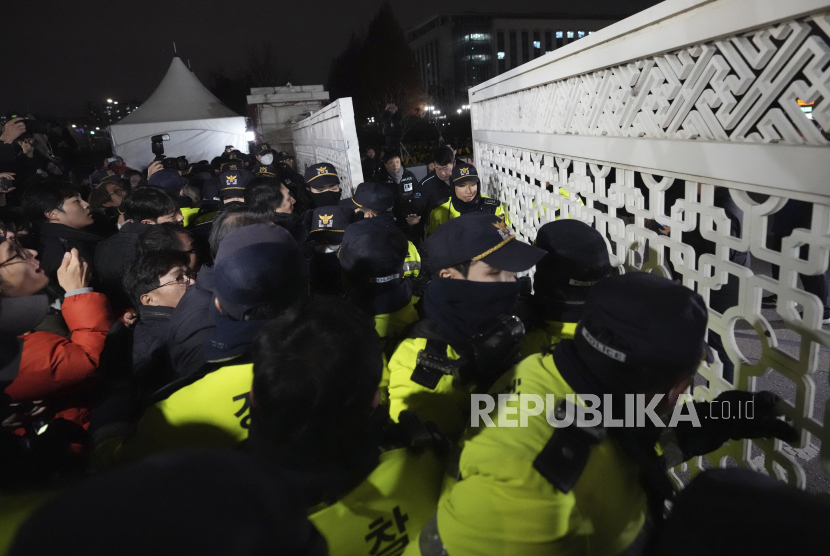 Orang-orang mencoba masuk saat petugas polisi berjaga di depan Gedung Majelis Nasional di Seoul, Korea Selatan, Selasa (3/12/2024).