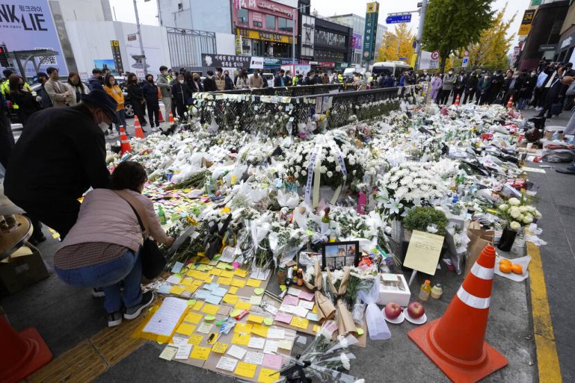 Orang-orang menempatkan bunga untuk memberi penghormatan kepada korban gelombang kerumunan mematikan yang menewaskan lebih dari 150 orang di lingkungan Itaewon selama perayaan Halloween Sabtu malam, di area peletakan bunga darurat yang didirikan di dekat lokasi kecelakaan di Seoul, Korea Selatan, Kamis, 3 November 2022.