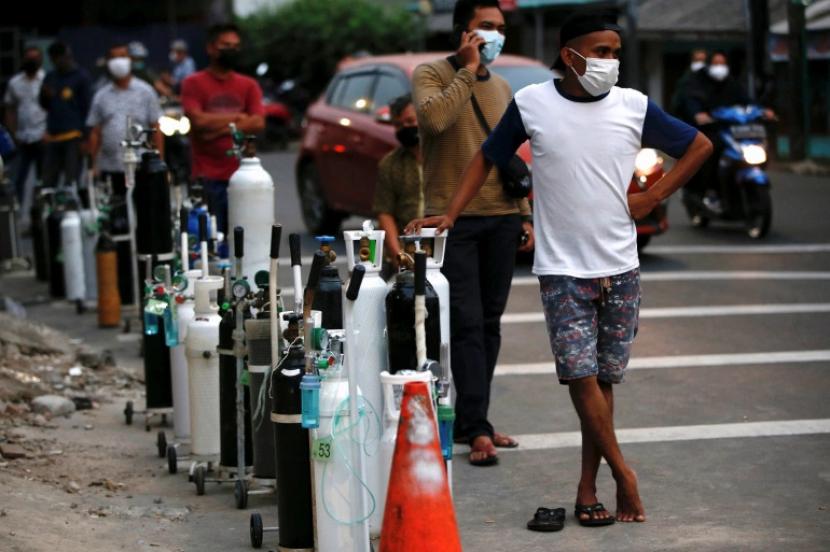 Orang-orang mengantri untuk mengisi tangki oksigen karena Indonesia mengalami kekurangan pasokan oksigen 