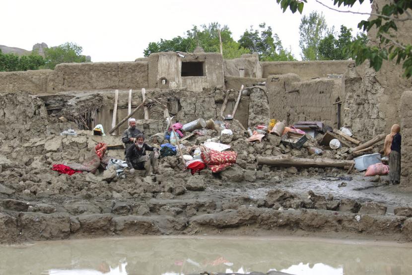 Orang-orang mengumpulkan barang-barang mereka dari rumah mereka yang rusak setelah banjir besar di distrik Khushi provinsi Logar selatan Kabul, Afghanistan, Minggu, 21 Agustus 2022.