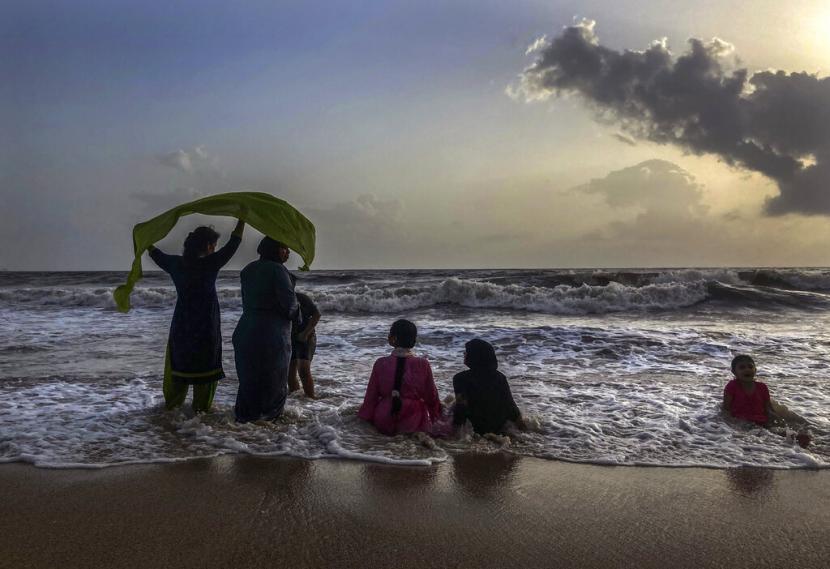 Orang-orang menikmati malam di pantai Juhu di pantai Laut Arab di Mumbai, India, Senin, 23 Mei 2022. Beberapa bulan terakhir, India menyaksikan kekerasan agama selama festival Hindu.