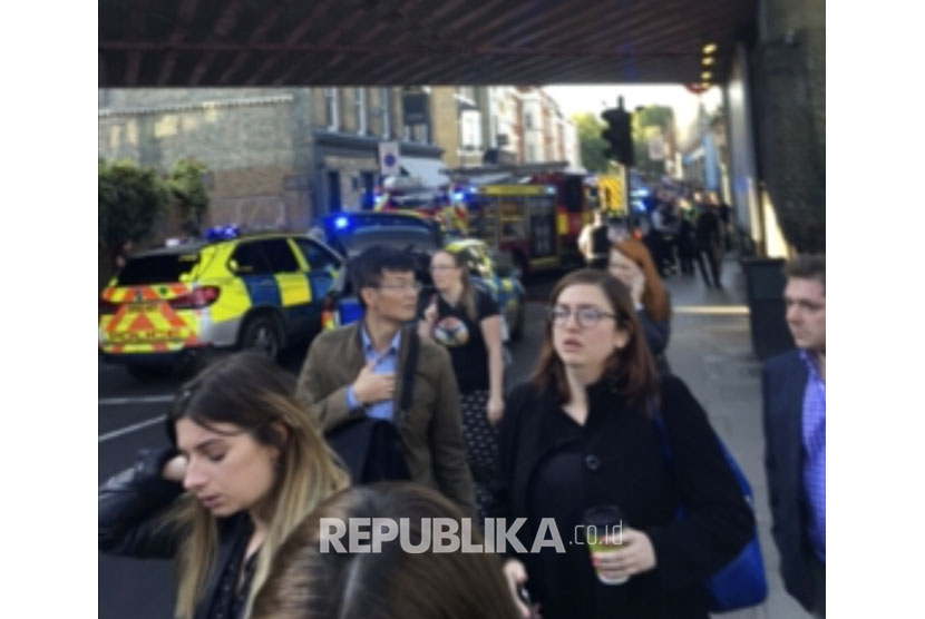 Orang-orang meninggalkan tempat kejadian ledakan di stasiun kereta bawah tanah London barat daya di London pada hari Jumat, (15/9).