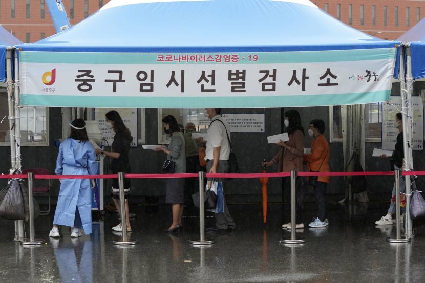 Orang-orang menunggu untuk mendapatkan pengujian virus corona di tempat pengujian darurat di Seoul, Korea Selatan, Selasa, 7 September 2021. Spanduk itu berbunyi: Situs pengujian darurat COVID-19.