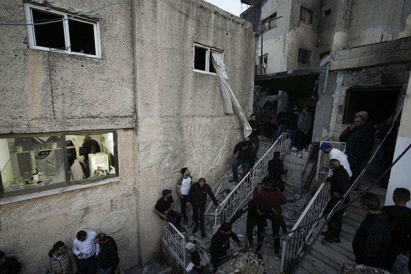 Orang -orang Palestina memeriksa bangunan yang rusak setelah serangan pasukan Israel di kamp pengungsi Tepi Barat Jenin, Selasa, 7 Maret 2023. 