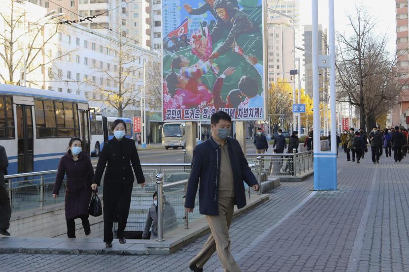 Orang-orang yang memakai masker berjalan di jalan di sepanjang Stasiun Kereta Api Pyongyang di Distrik Pusat Pyongyang, Korea Utara, Jumat, 4 November 2022. 