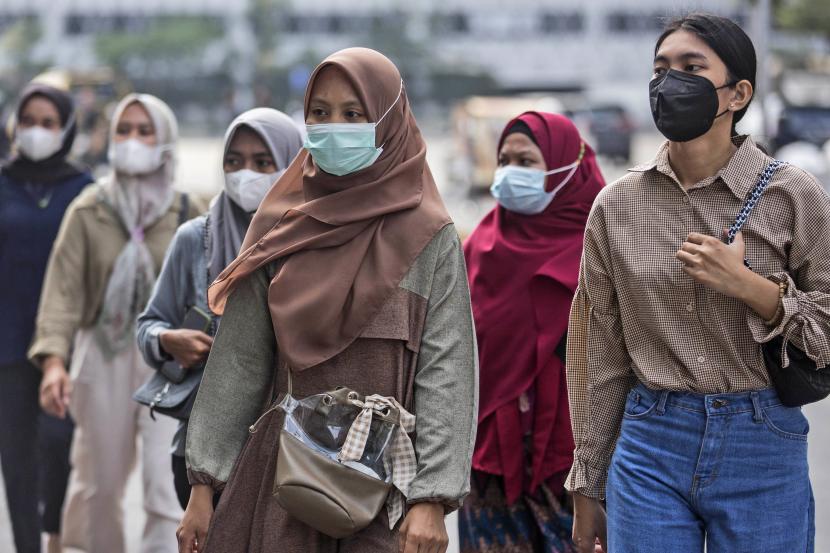 Orang-orang yang memakai masker untuk menahan penyebaran wabah COVID-19 berjalan di stasiun kereta api di Medan, Sumatera Utara, Sabtu, 29 Januari 2022. 