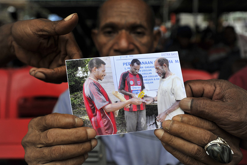 Orang tua korban kecelakaan pesawat Trigana Air PK-YRN Matius menunjukkan foto anaknya Eki Kimki yang menjadi penumpang pesawat naas tersebut di crisis center kompleks Bandara Sentani, Kabupaten Jayapura, Papua, Selasa (18/8).