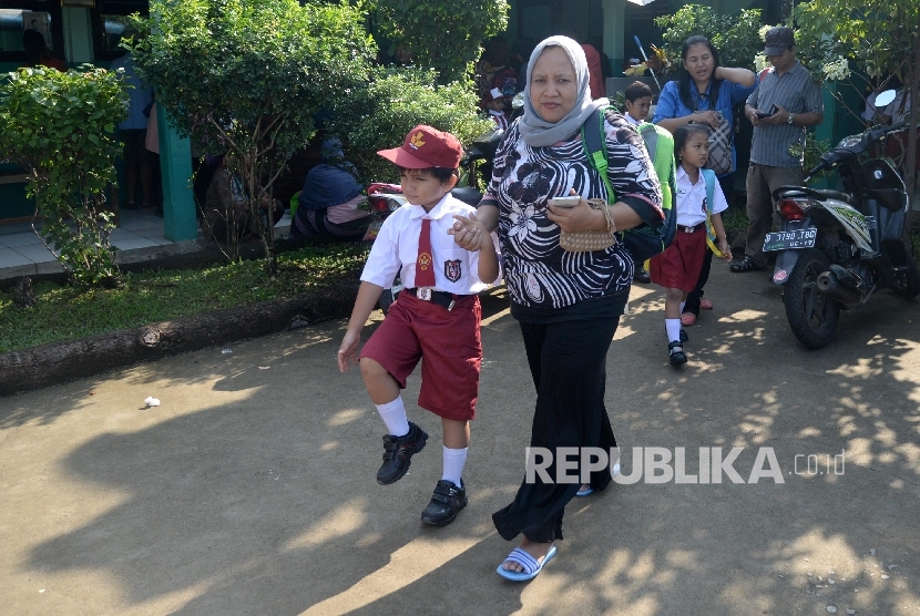 Orang tua mendampingi murid saat hari pertama sekolah di SDN Malaka Sari 04 Pagi, Jakarta Timur, Senin (18/7).Republika/Yasin Habibi