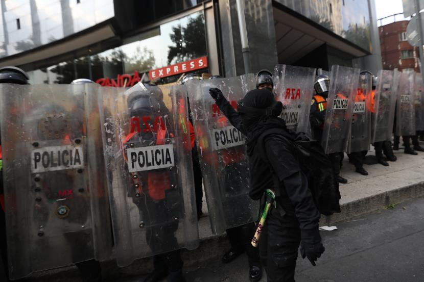 Organisasi feminis dan masyarakat sipil menghadapi polisi selama protes pada kesempatan Hari Internasional untuk Penghapusan Kekerasan terhadap Perempuan di Mexico City, Meksiko, 25 November 2021.