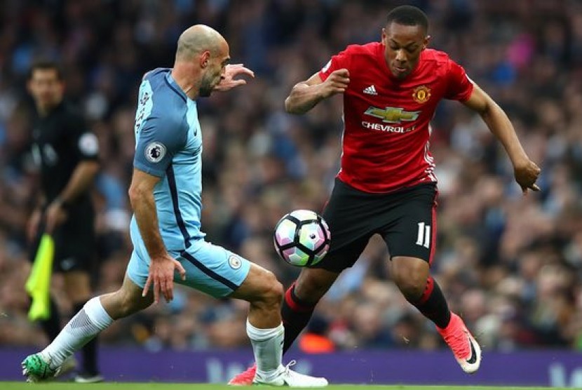 Pablo Zabaleta (kanan) menghadang Anthony Martial dalam Derby Manchester, Jumat (28/4).